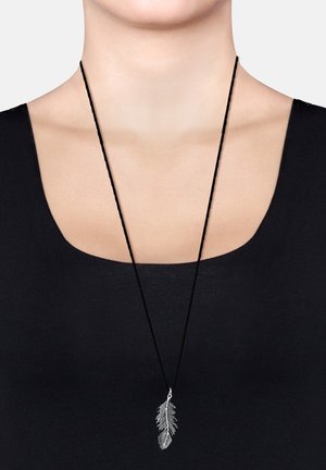 Sølvfjer-vedhæng på en sort snorhalskæde, præsenteret mod en sort top. Vedhænget har detaljerede bladdesign og en poleret finish.