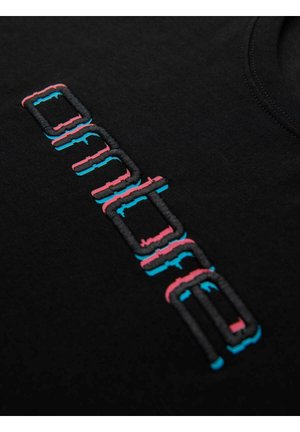 Svart skjorta med broderad text i rosa och blått. Texten har en blockig, modern design med en taktil textur. Rund halsringning.