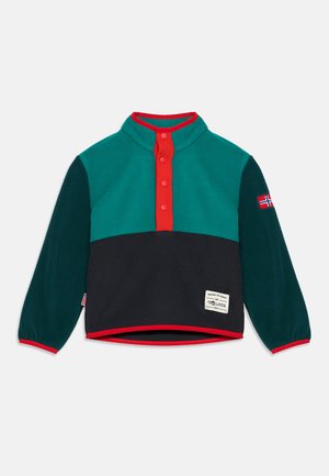 Pull polaire enfant à manches longues avec des blocs de couleurs bleu sarcelle et vert foncé, patte de boutonnage rouge, écusson du drapeau norvégien et étiquette à l'avant.
