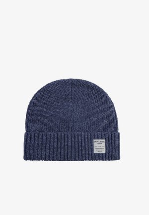 Gorro de punto azul marino con un puño acanalado, que presenta una pequeña etiqueta tejida con los detalles de la marca en el lateral. Textura suave y ajuste flexible.