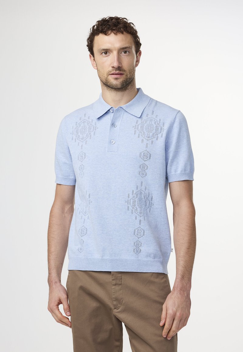 Vaaleansininen polo-paita lyhyillä hihoilla, jossa on teksturoitu kuvio edessä, kaksinappinen kaulus ja suora helma.