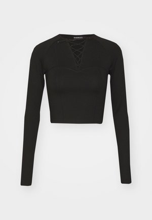 Sort langærmet crop top lavet af glat stof, med snørelukning i halsudskæringen og strukturerede sømme for en tætsiddende pasform.