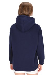 Sudadera con capucha azul marino en tela suave. Presenta un ajuste holgado, mangas largas y un dobladillo acanalado, con una capucha espaciosa para mayor calidez.