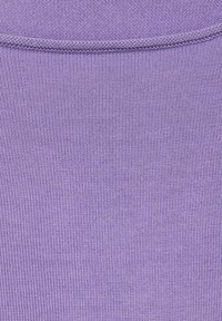 Lila stickad tyg med fin textur; enhetlig färg; inga synliga mönster eller hårdvara. Slät finish med en lätt stretch.