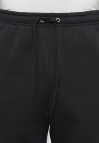 Sorte sweatpants lavet af blødt stof, med elastisk talje, snorelukning og side-syning detaljer.