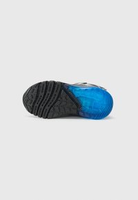 Sko såle med en teksturert svart gummibase og et gjennomsiktig blått område, som viser en lagdelt design og grep-riller.