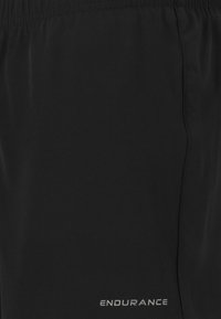 Svarta idrottsshorts av lättviktig tyg med resårmidja och silverfärgad "ENDURANCE"-logotyp på den nedre sidan.