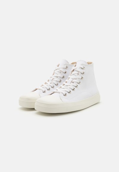 Höga vita kanvas sneakers med gummikåpa, metallöglor och vit snörning. Lättviktig design med en texturerad yta.