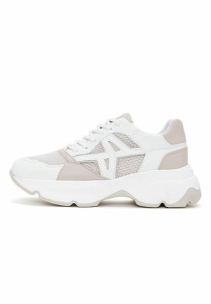 Zapatillas con un diseño en blanco y beige claro, materiales de malla y sintéticos, forma redondeada y suela gruesa blanca con un borde ondulado.