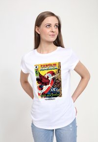 Bílé tričko s krátkým rukávem, které má barevný potisk obálky komiksu s Kapitánem Amerikou, včetně výrazného textu a ilustrovaných postav.