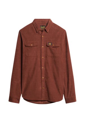 Brun kordfløjls skjorte med lange ærmer, knaplukning foran, to brystlommer og et mærke på venstre lomme. Glat tekstur.