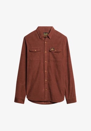 Brun kordfløjls skjorte med lange ærmer, knaplukning foran, to brystlommer og et mærke på venstre lomme. Glat tekstur.