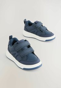 Granatowe sneakersy wykonane z materiału syntetycznego z białą podeszwą. Cecha charakterystyczna to dwa paski na rzepy i teksturowane akcenty po bokach.