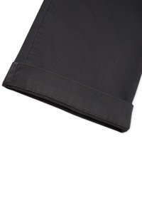 Black trousers with a folded hem. Made from textured fabric. Features a clean cut with a simple design and no visible hardware or accents.