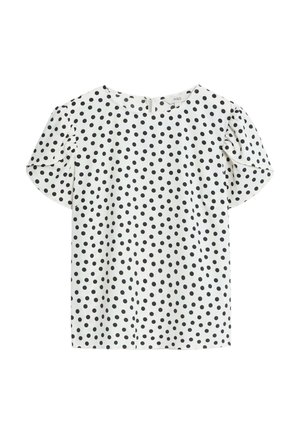 Blusa bianca a maniche corte con pois neri, collo rotondo e tessuto morbido, leggermente texturizzato. Presenta delicate maniche a sbuffo.