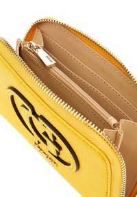 Portafoglio giallo in pelle con logo nero, chiusura con zip e scomparti interni, inclusi un piccolo taschino con zip e slot per carte.