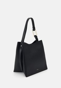 Sac fourre-tout en cuir noir avec une finition texturée, une forme structurée, une seule sangle ajustable et un accent logo doré à l'avant.