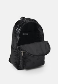 Svart ryggsäck gjord av glänsande material, med ett huvudsakligt fack som stängs med dragkedja och en innerficka, präglade logodetaljer och justerbara remmar.