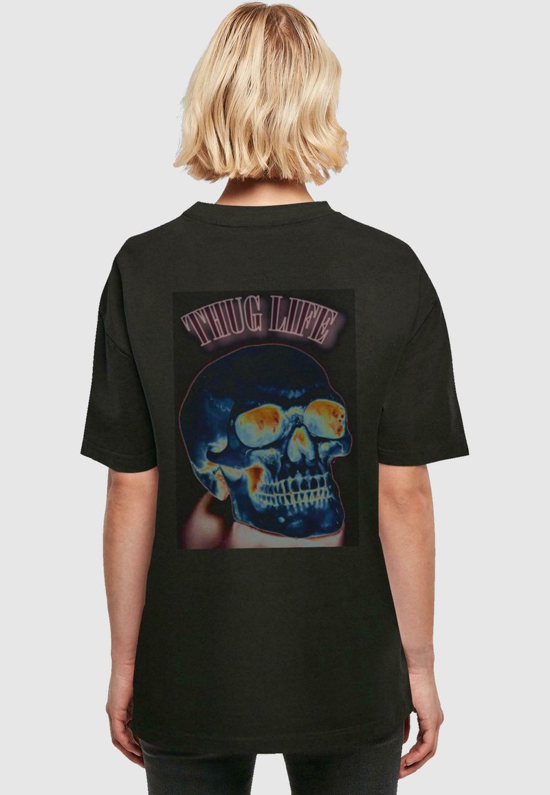 Svart T-skjorte med korte ermer som har et fargerikt hodeskalle-motiv og teksten "THUG LIFE" på baksiden. Designet har en glansfull tekstur.
