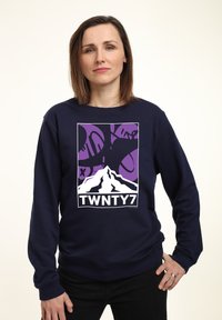 Felpa blu navy con un design grafico che presenta una montagna e forme astratte in viola e nero, con l'etichetta "TWNTY7" in basso.