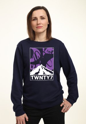 Tmavě modrá mikina s grafickým designem s horou a abstraktními tvary v purpurové a černé barvě, označena "TWNTY7" na spodní části.