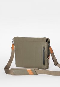 Borsa a tracolla verde oliva con pelle liscia e tessuto texturizzato. Presenta una tasca frontale con cerniera e una tracolla regolabile e rimovibile.