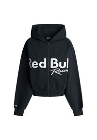 Crna zip-up pumpa s kapuljačom, sa velikim bijelim tekstom "Red Bull Racing" sprijeda. Izrađena od mekane teksturirane tkanine.