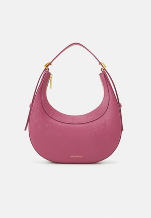 Torebka Coccinelle z teksturowanej różowej skóry, o zaokrąglonym kształcie, z akcentami w kolorze złotym i krótkim uchwytem ułatwiającym noszenie.