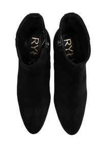 Czarne zamszowe botki za kostkę z szpiczastymi noskami, bocznymi zamkami błyskawicznymi i gładką matową teksturą. Złote logo widoczne w środku.