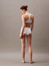 Witte katoenen sportbeha en slipjes met een racerback-design. Bevat een Calvin Klein logo band, minimale naden en een gladde textuur.