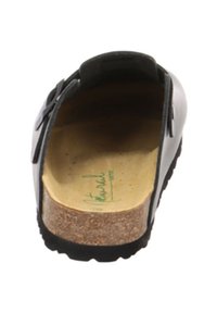 Schwarzer Clog mit offenem Rücken, verstellbarem Seitenverschluss, Korkfußbett und Gummisohle, von der Ferse aus betrachtet.