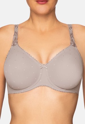 Frau trägt einen hell mauvefarbenen BH mit dezenten Polka-Dots und Spitzenverzierung an den Trägern, zeigt oberen Torso und Hals.