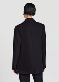 Blazer nero con design strutturato, rever a incavo e spacco singolo. Tessuto liscio con una vestibilità leggermente sagomata e maniche lunghe.