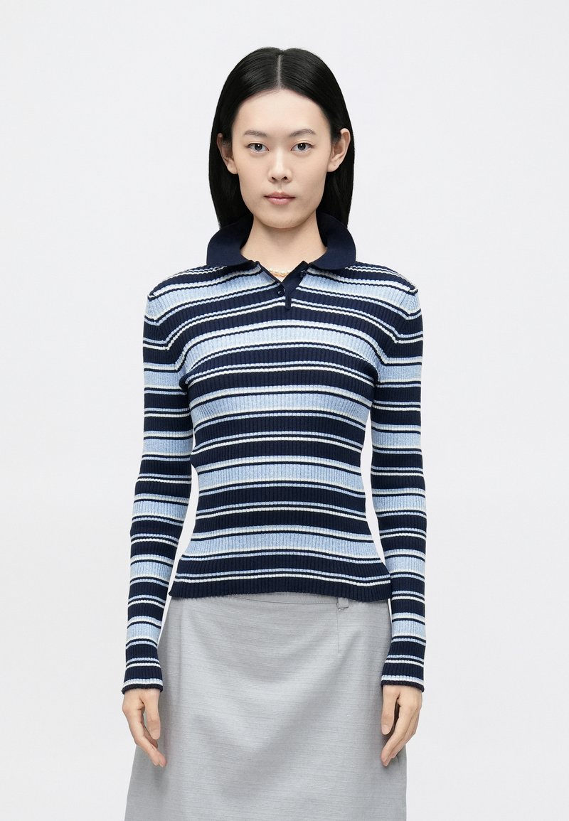 Ριγέ πλεκτό πόλο μπλουζάκι με οριζόντιες ρίγες σε ναυτικό μπλε, ανοιχτό μπλε και λευκό, με ριμπ υφή, μακριά μανίκια και γιακά στο λαιμό.