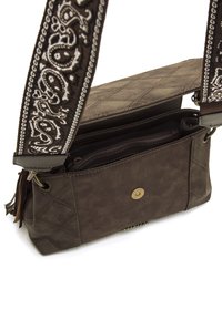 Borsa a tracolla in pelle marrone con texture trapuntata, fascetta decorativa con motivo bianco e chiusura a pulsante frontale. Tasche interne visibili.
