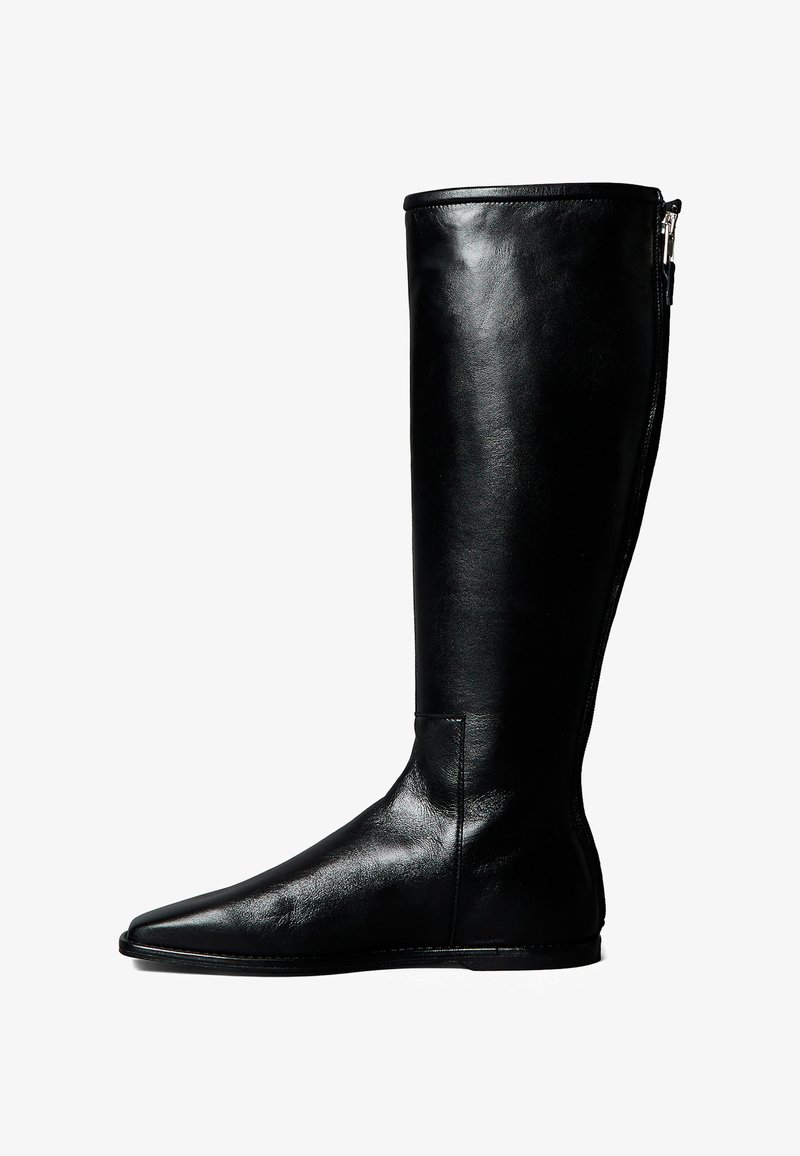 Bota negra de cuero hasta la rodilla con punta afilada, cremallera lateral y textura suave. Presenta una silueta ajustada y detalles de costura sutiles.