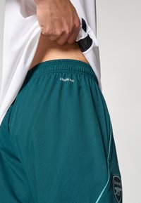 Teal athletic shorts with an elastic waistband, "AEROREADY" logo on the back, and contrasting light cyan accents along the sides.