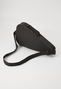 Saco de ombro preto feito de tecido durável, com uma forma triangular elegante, alça ajustável e um design minimalista com um fecho de correr.