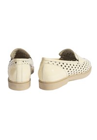 Beige Slippers mit durchbrochenem Design und glänzender Textur. Runde Zehenpartie, weiche Innensohle und beigefarbene Gummisohle.