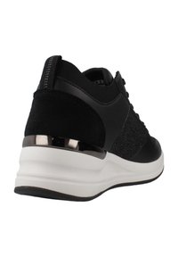 Zapatilla deportiva negra que presenta una combinación de material sintético suave y tela texturizada. Suela blanca acolchada con un acento de tacón negro brillante.