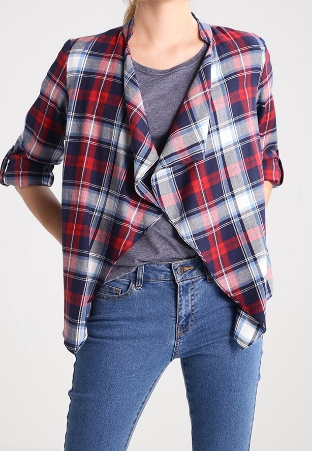 Rutigt skjorta i marinblått, rött och vitt, med en draperad front och korta ärmar, lager på en grå topp och matchat med blå jeans.