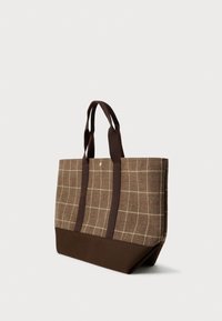 Καφέ τσάντα tote με καρό υφασμάτινο επάνω μέρος, σταθερή σκούρα καφέ βάση και δύο σκούρες καφέ λαβές σε απλό ανοιχτό φόντο.