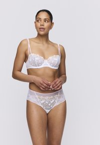 Biały koronkowy stanik z kwiatowym haftem, w komplecie z pasującymi koronkowymi majtkami. Posiada różowe ramiączka, przezroczystą fakturę i dekoracyjne akcenty w formie kwiatów.