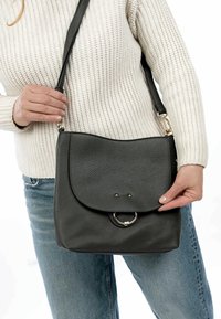 Borsa a tracolla in pelle grigia con pattina arrotondata, dettagli in metallo dorato e superficie testurizzata. Tracolla regolabile per un trasporto versatile.