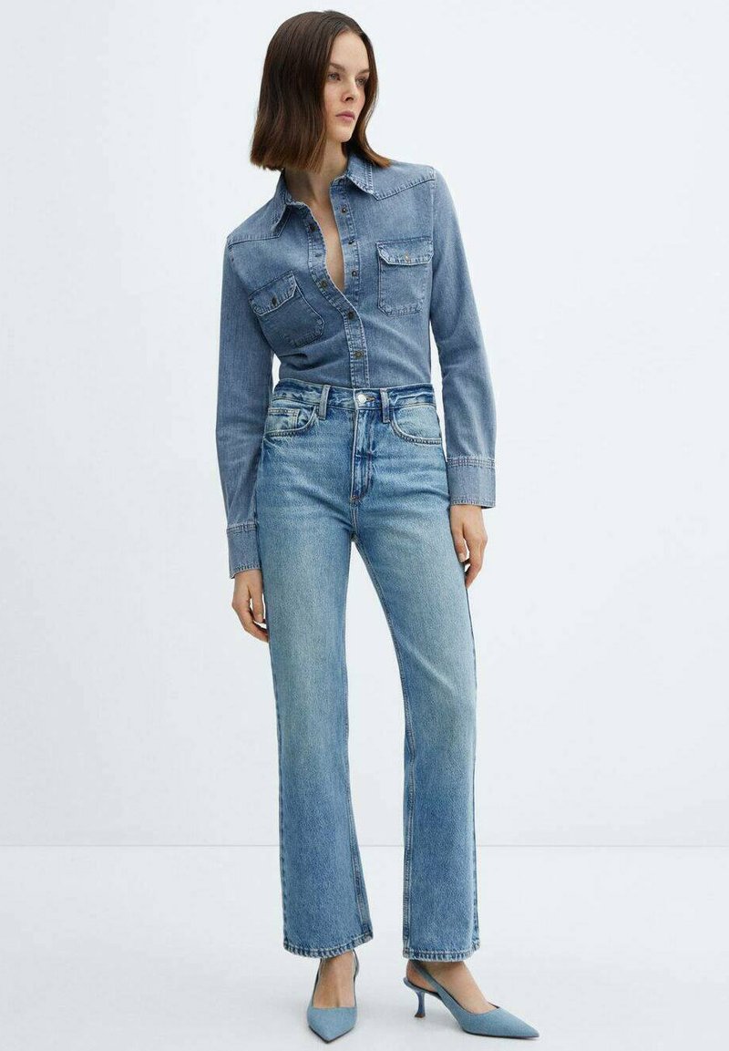 Hellblaues Denim-Hemd mit langen Ärmeln, Knopfdesign, kombiniert mit hoch taillierten, hellen, geraden Jeans und blauen spitzen Absätzen.