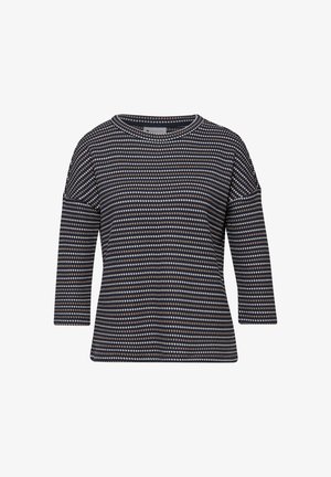 Granatowy sweter z białym i beżowym wzorem z małych diamentów, okrągłym dekoltem i rękawami do połowy przedramienia.