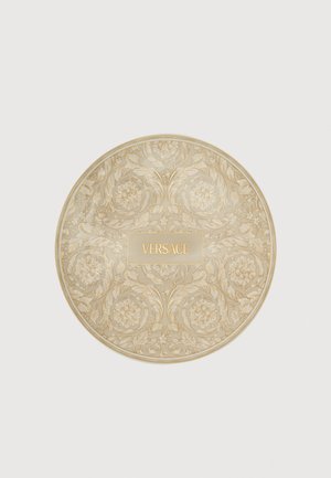 Okrągłe, beżowo-złote, dekoracyjne etui z kwiatowymi, barokowymi wzorami i napisem "VERSACE" wytłoczonym na środku.