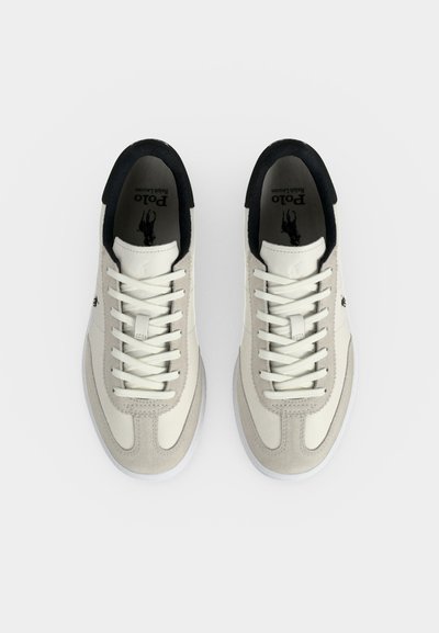 Pereche de sneakers Polo Ralph Lauren albi și gri deschis cu căptușeală interioară neagră și șireturi albe, prezentate vedere de sus pe fundal alb.
