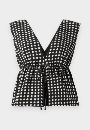 Black and white polka dot top with a deep V-neck, sleeveless design, gathered waist with adjustable tie, and smooth fabric texture.