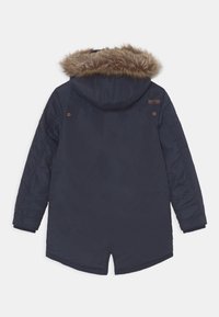 Námořnická modrá parka s kapucí podloženou umělou kožešinou, žebrovanými manžetami a postranními rozparky. Hladká textura s označením značky na horní části zad.